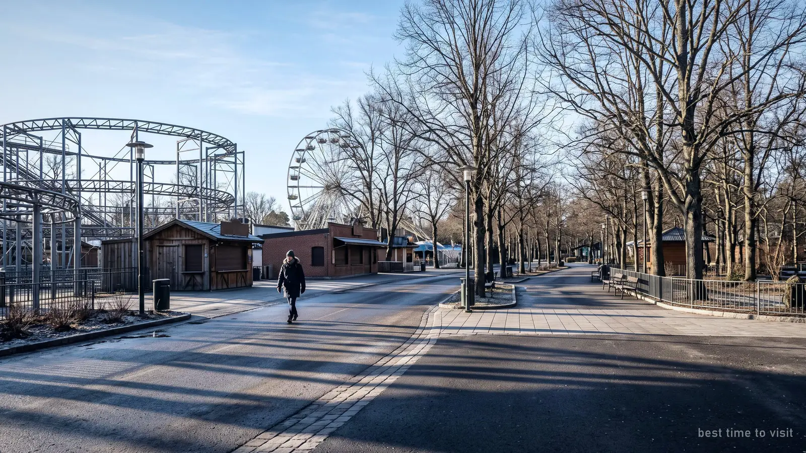 A near-empty park walkway on a cold bright winter morning, long shadows and bare trees